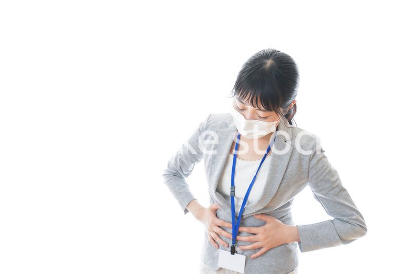 腹痛に苦しむ若いビジネスパーソン