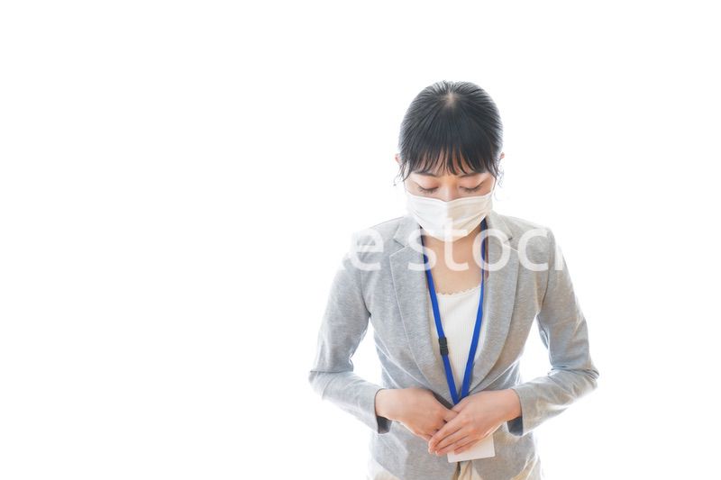 マスクをしてお辞儀をする若いビジネスパーソン