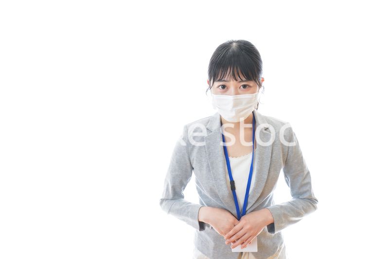 マスクをしてお辞儀をする若いビジネスパーソン