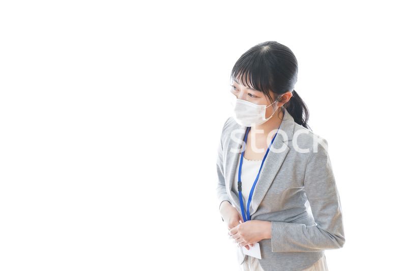 マスクをしてお辞儀をする若いビジネスパーソン