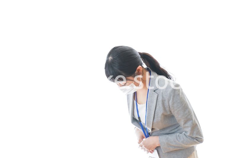 マスクをしてお辞儀をする若いビジネスパーソン