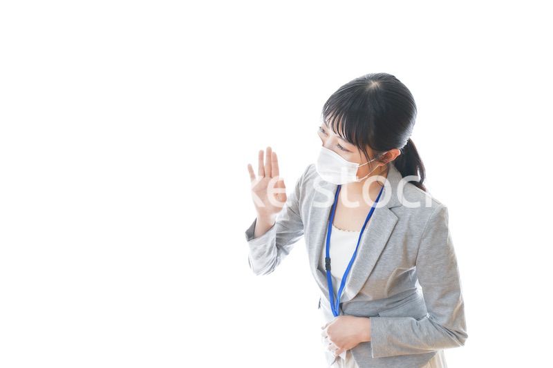 マスクをしてお辞儀をする若いビジネスパーソン