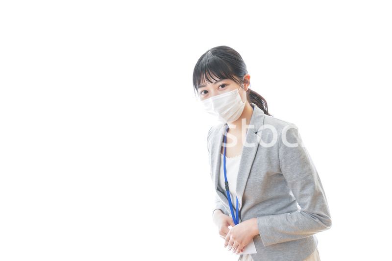 マスクをしてお辞儀をする若いビジネスパーソン