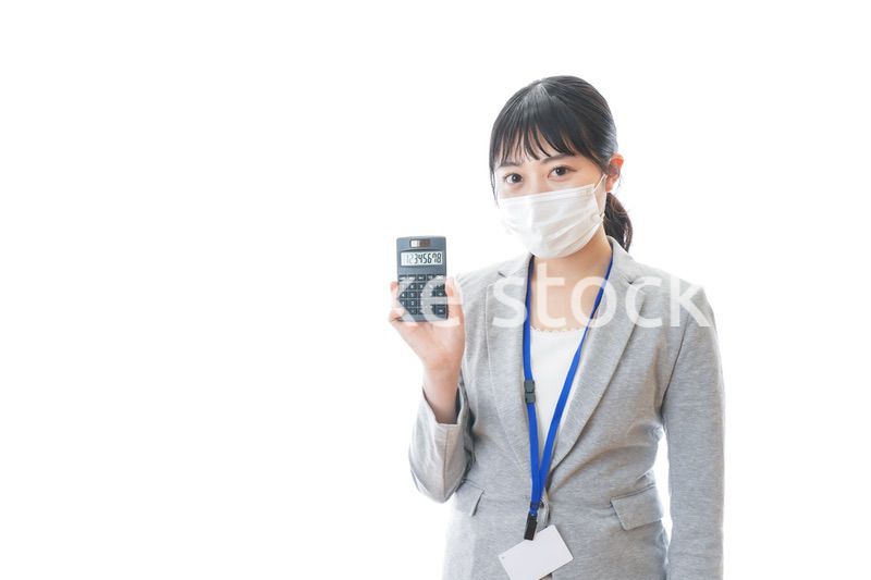 マスクをして電卓を持つ若いビジネスパーソン