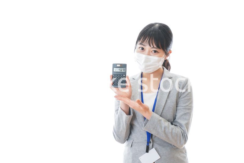 マスクをして電卓を持つ若いビジネスパーソン