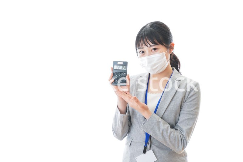 マスクをして電卓を持つ若いビジネスパーソン