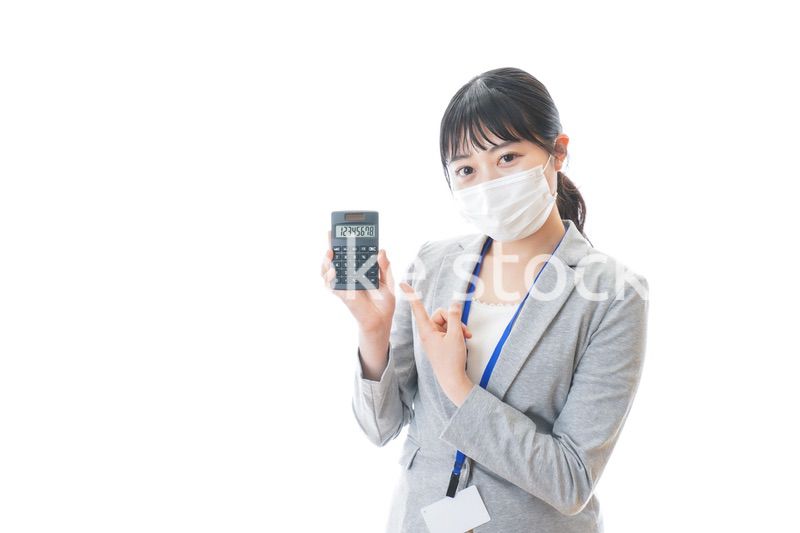 マスクをして電卓を持つ若いビジネスパーソン