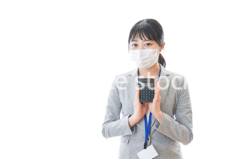 マスクをして電卓を持つ若いビジネスパーソン