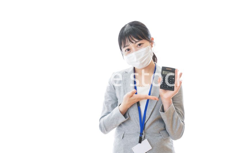 マスクをして電卓を持つ若いビジネスパーソン