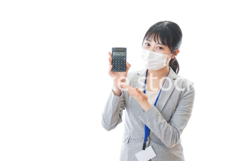 マスクをして電卓を持つ若いビジネスパーソン