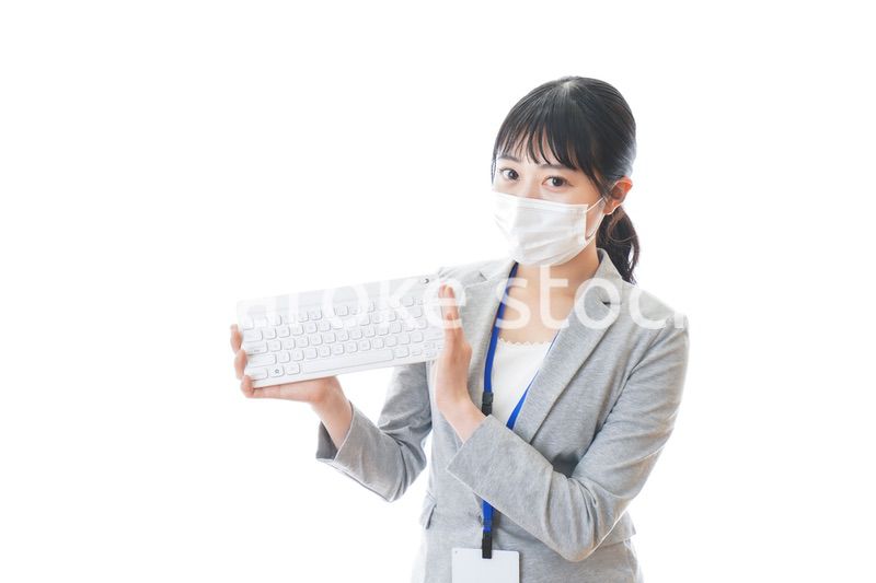 マスクをしてキーボードを持つ若いビジネスパーソン