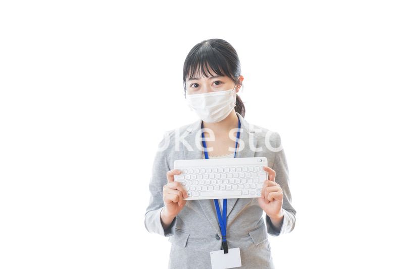 マスクをしてキーボードを持つ若いビジネスパーソン
