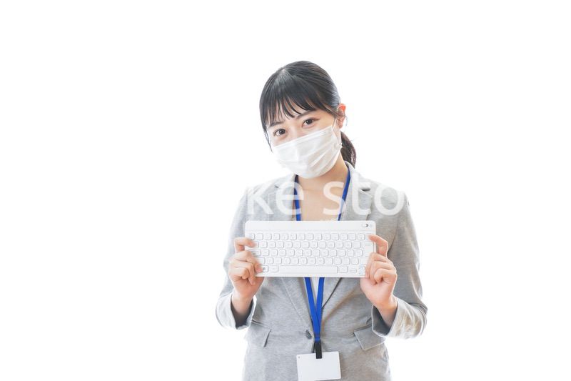マスクをしてキーボードを持つ若いビジネスパーソン