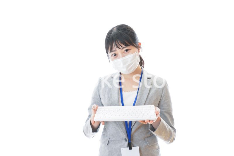 マスクをしてキーボードを持つ若いビジネスパーソン
