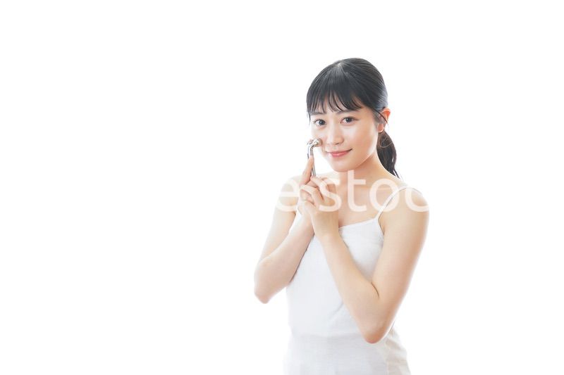 かっさで肌をマッサージをする若い女性