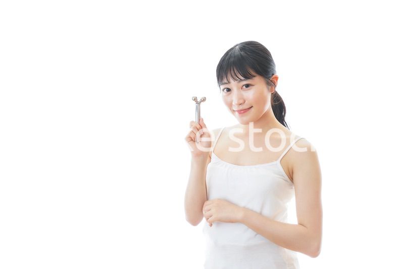 かっさで肌をマッサージをする若い女性