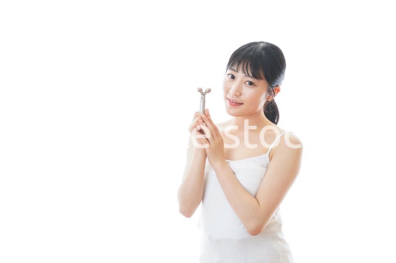 かっさで肌をマッサージをする若い女性