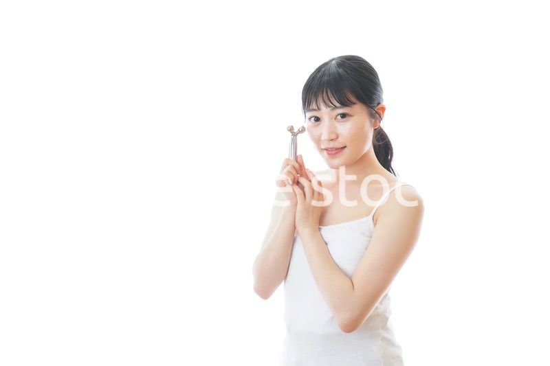 かっさで肌をマッサージをする若い女性