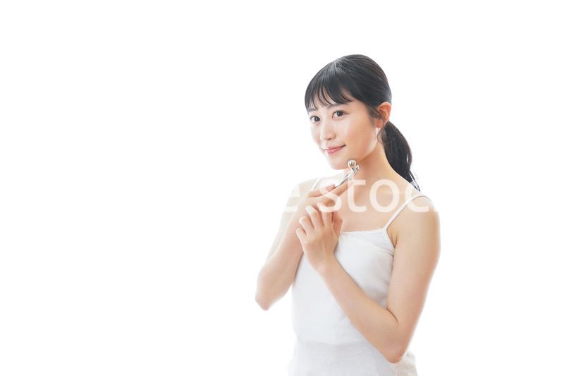 かっさで肌をマッサージをする若い女性