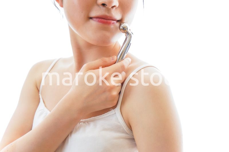 かっさで肌をマッサージをする若い女性