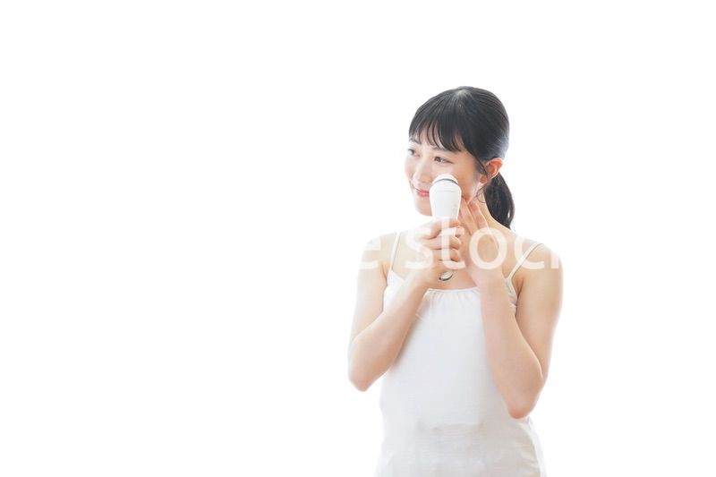 美容機器を使う若い女性