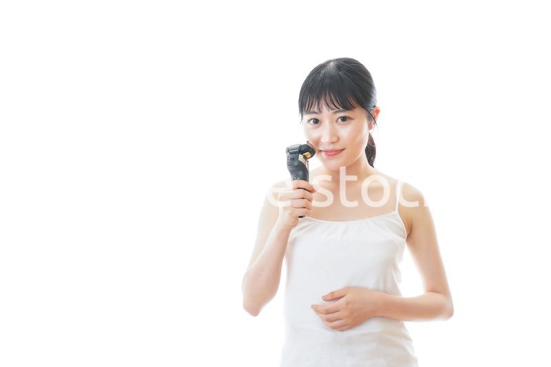 髭剃りを使う若い女性