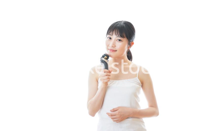 髭剃りを使う若い女性