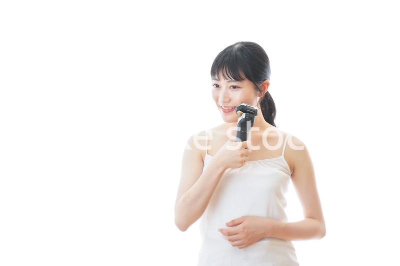 髭剃りを使う若い女性