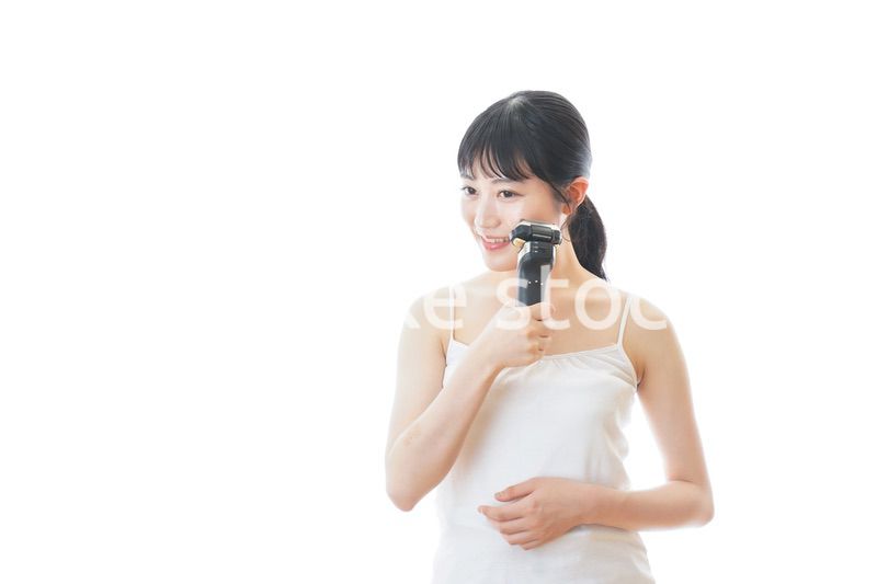 髭剃りを使う若い女性