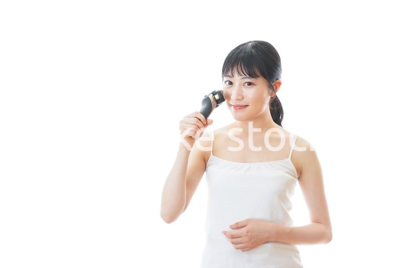 髭剃りを使う若い女性