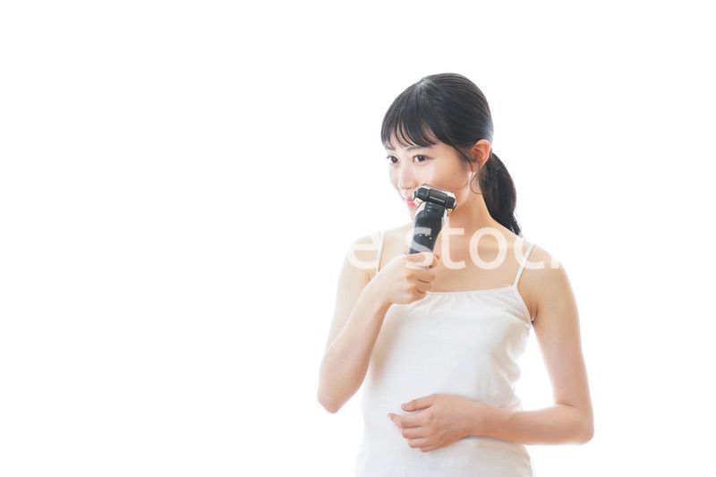 髭剃りを使う若い女性