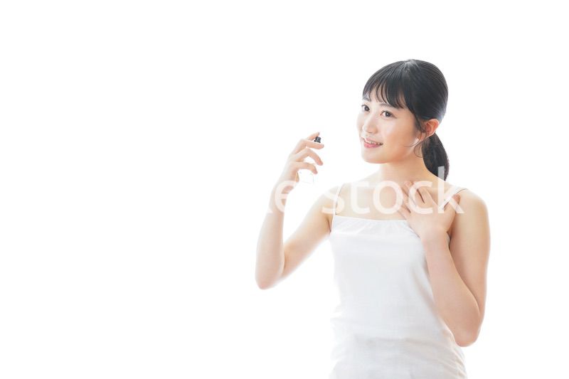 香水を使う若い女性