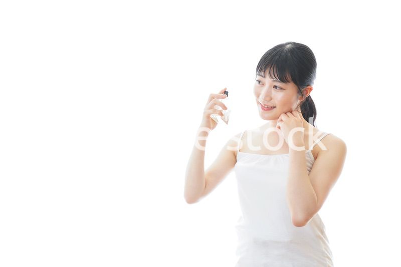 香水を使う若い女性