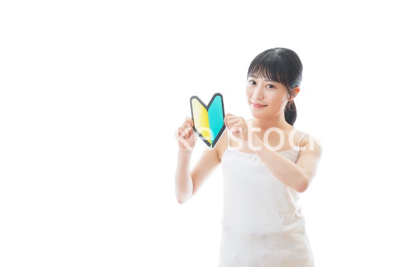 初心者マークを持つキャミソールをきた若い女性