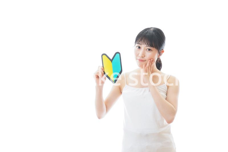 初心者マークを持つキャミソールをきた若い女性