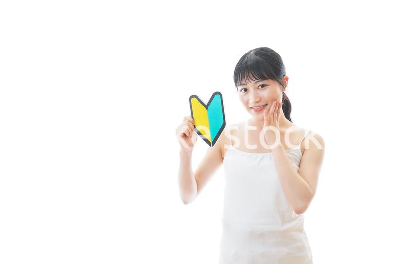 初心者マークを持つキャミソールをきた若い女性