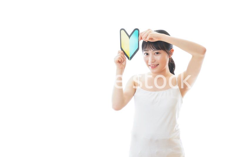 初心者マークを持つキャミソールをきた若い女性