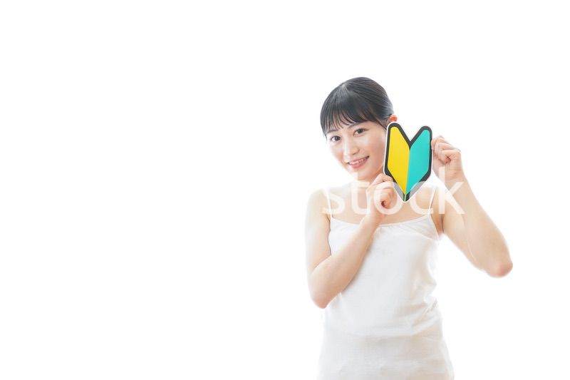 初心者マークを持つキャミソールをきた若い女性