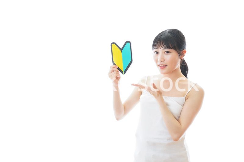 初心者マークを持つキャミソールをきた若い女性