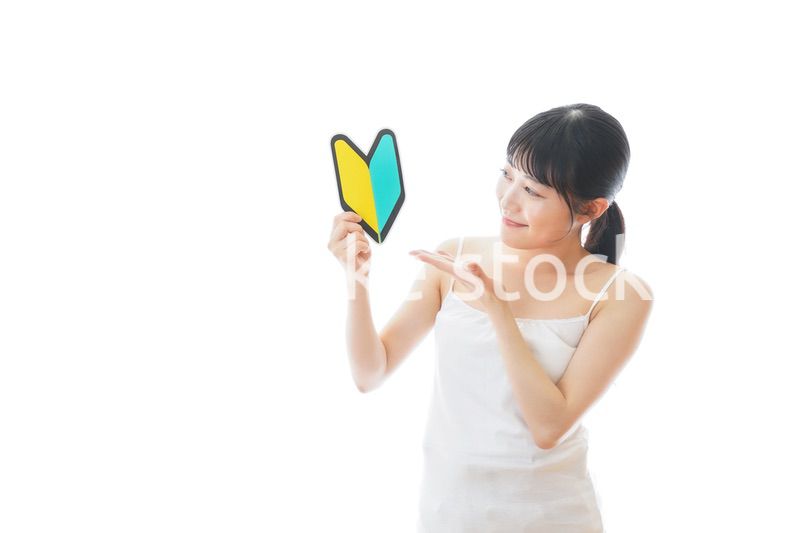 初心者マークを持つキャミソールをきた若い女性