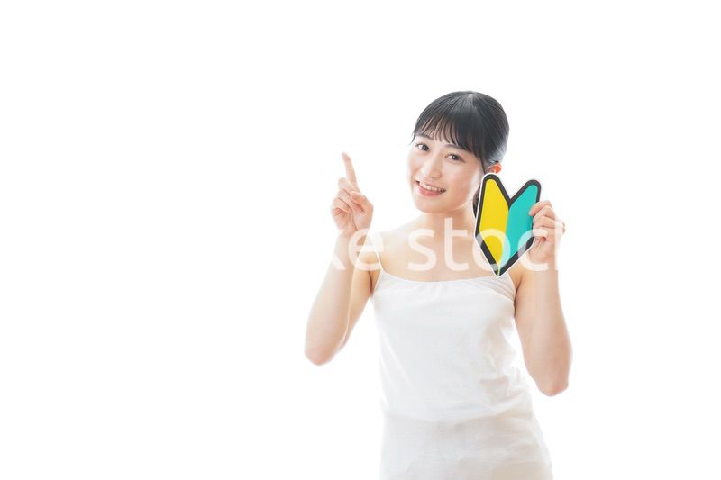 初心者マークを持つキャミソールをきた若い女性