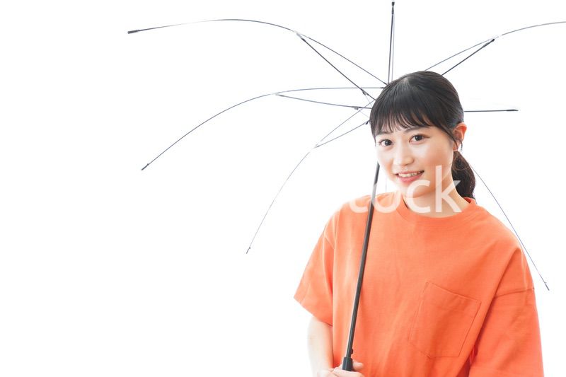 ビニール傘を指す若い女性