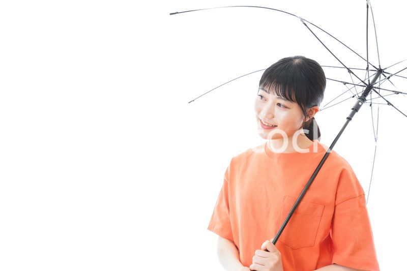 ビニール傘を指す若い女性