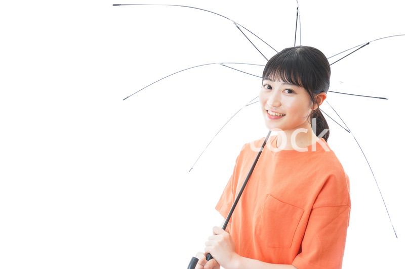 ビニール傘を指す若い女性