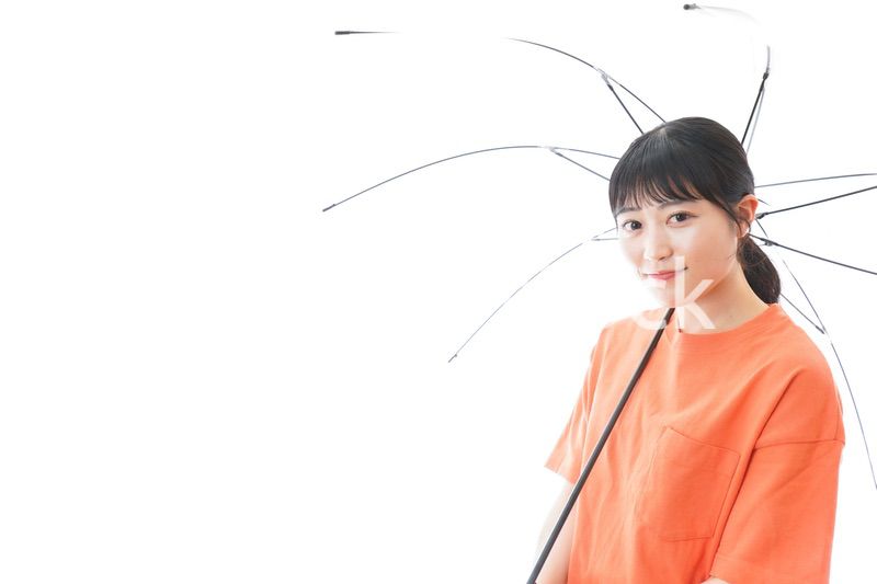 ビニール傘を指す若い女性