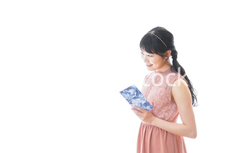 パーティーの招待状を持つ若い女性