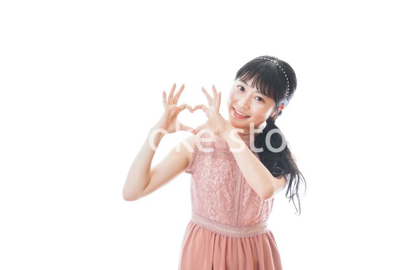 指でハートマークを作る若い女性