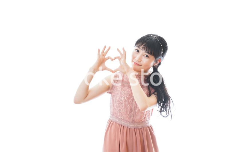 指でハートマークを作る若い女性