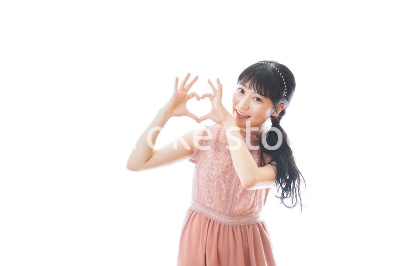 指でハートマークを作る若い女性