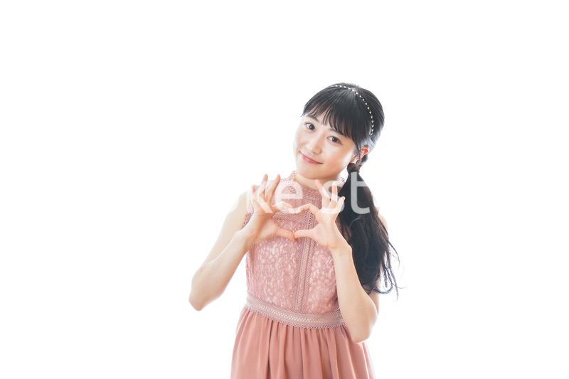 指でハートマークを作る若い女性